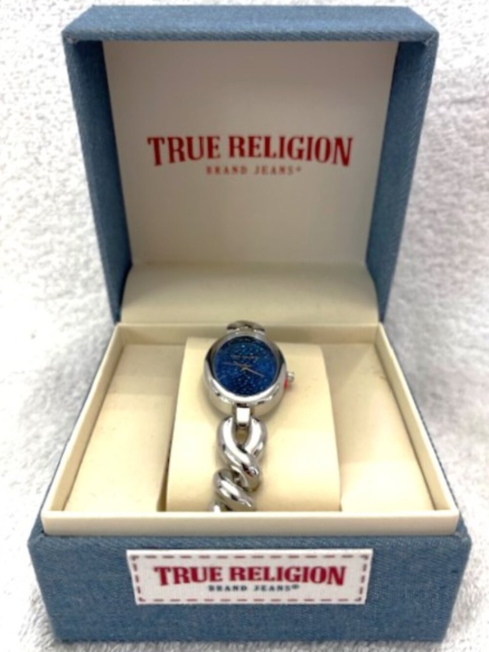 True Religion oval shaped watch with silver tone bracelet style band. New in Box